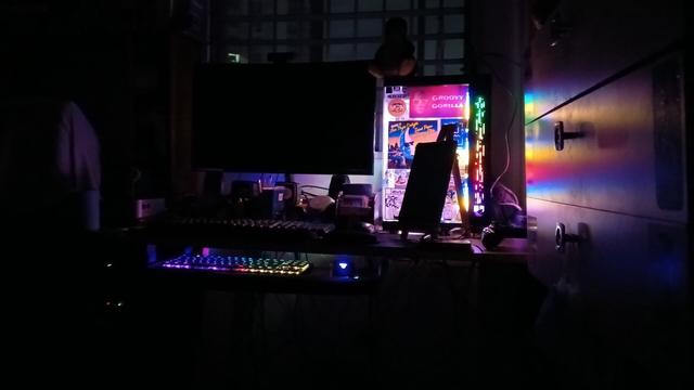 A photo of a gaming PC with it's RGB on in a dark room.