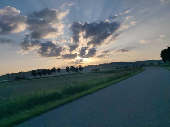 Lockere Wolken am frühen Morgenhimmel. Sonne "strahlt" dahinter
