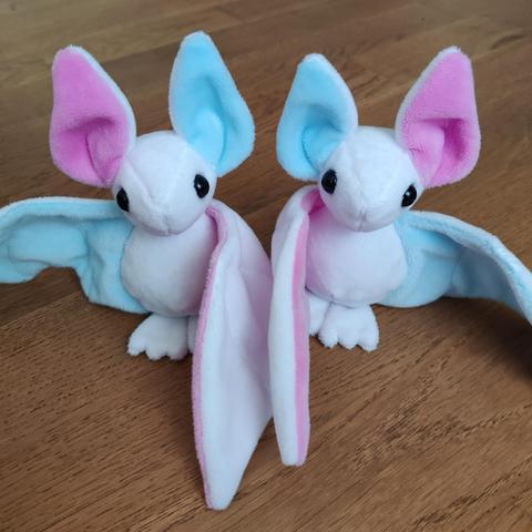 The same two bats with their wings open.