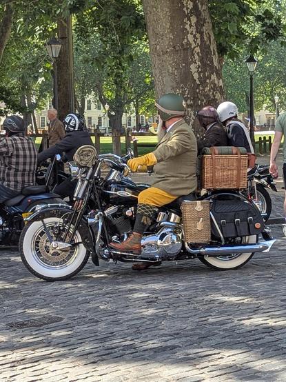 Photo of a distinguished gentleman on his motorbike.  He has some lovely yellow riding trousers, long socks, yellow driving gloves and a resplendent pipe.