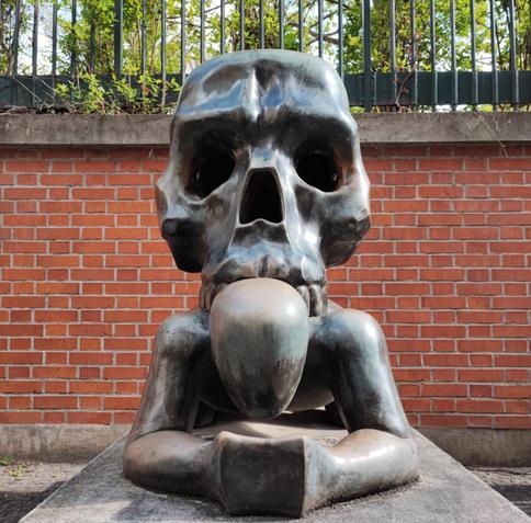 Sculpture of skull bearing beggar on all fours.