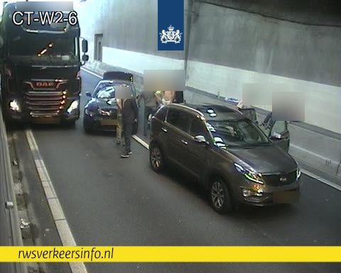 Twee auto's staan in de Coentunnel na een ongeval en een vrachtwagen staat ernaast