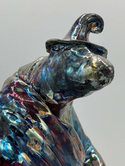 A close up of the face/shoulder of a raku fired bear.