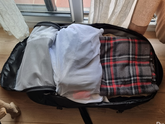Le même filet bourré dans un sac à dos de voyage, sac à dos lui aussi posé au sol