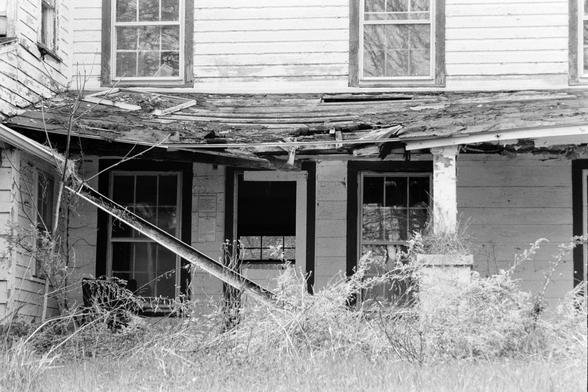 The decaying front porch of an abandoned house