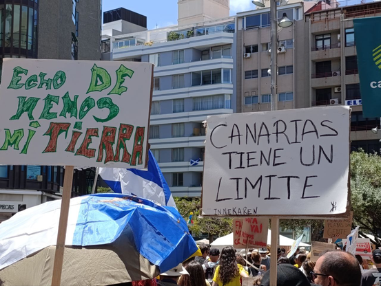 Carteles de la manifestación: "Echo de menos mi tierra" y "Canarias tiene un límite".