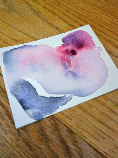 This watercolor swatch is made using Schmincke Wild Purple and Shadow Grey. The wild purple masstone is more red than purple and the water pushes it to granulate into bursts of vibrant bright pink and grittier blue. With more water, the colors are just a lighter value. The shadow grey is a smokey blue and granulates similar to the blue in the wild purple; however it leaves a black edge.