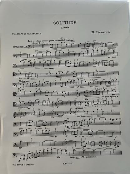 Une page de partition intitulée "Solitude", composée par R. Strohl pour piano et violoncelle. La musique est imprimée à l'encre noire sur du papier blanc, avec des notes de musique, des symboles et des instructions de performance en français et en italien.