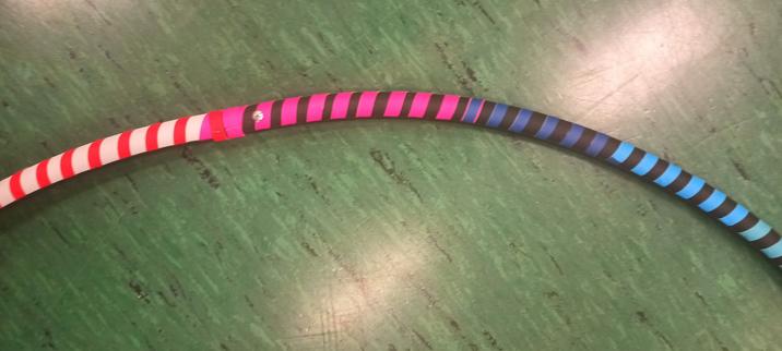 Großaufnahme des Regenbogenreifens. Hier die Farben hellblau, dunkelblau und pink immer neben schwarz, linka feuerrot neben weiß.