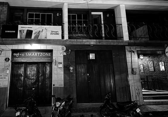 Monochrome photo of a Tigo store and Pub York in Leon, Nicaragua