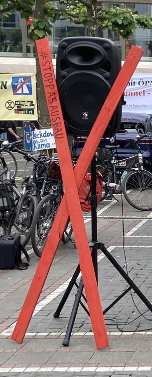 Rotes Kreuz aus 2m Dachlatten lehnt an Lautsprecher.