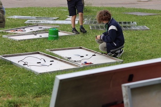 Symbolbild Menschen beim Steckersolar Upcycling. Es liegen Panels auf dem Boden und bekommen neue Stecker.