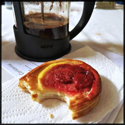 A French press and a half eaten pastry