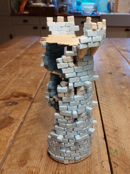 Four level ruined Castle Tower built inside and around a Pringles can, with near perfect arrow slits on the upper three levels, a roof platform with overhanging battlements, and a nice hardwood floor. Oh and one side has collapsed. Why hasn't the entire tower then, you ask? Well, that's because I've used XPS, which is lightweight and can stand a lot of bullying.