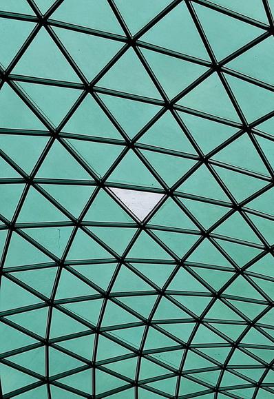Detail of the geodesic roof over the British Museum Reading Room. At the centre, one of the triangular glass panels has its solar film missing and is lit up white instead of light green. My wife wishes to point out that she spotted that it would make an interesting photo!