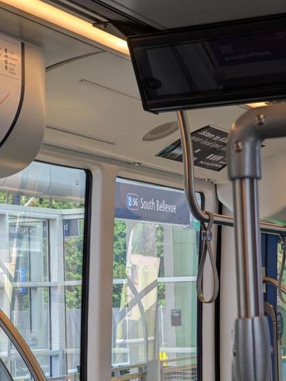 A view across a train, with a station sign visible outside the window that says 2 (station number 56) South Bellevue