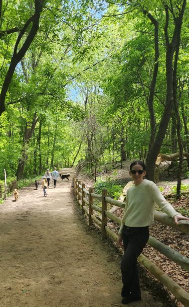Photo in High Park Toronto.  One of the extensive paths in the off leash area. My youngest daughter is leaning on a log fence on the right, and farther down the path through a wooded area, are my granddaughter and Harley our dog running after a pair of dogs.