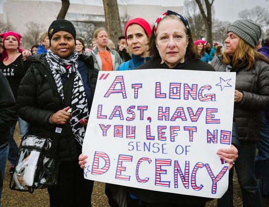 Literate protesters invoke McCarthy hearings, carrying a sign with the classic quotation, "At long last, have you left no sense of decency?"