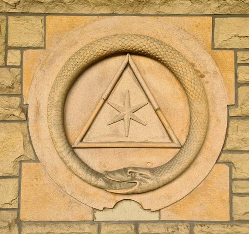 A symbol consisting of a snake eating its own tail surrounding a triangle and a six-pointed star.