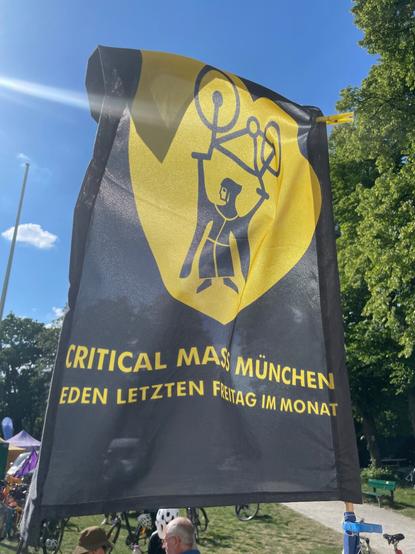 Eine schwarze Fahne mit dem Logo der CM München in gelb, und den Hinweis „jeden letzen Freitag im
Monat“