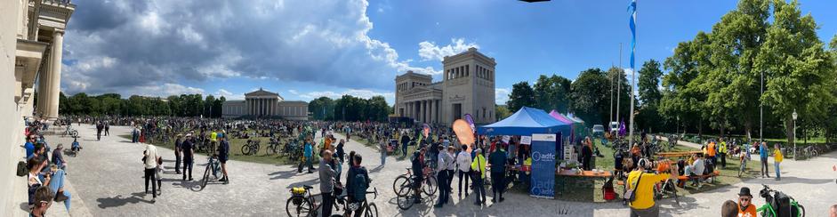 Ein Panorama Schwenk über den Königsplatz in München, voll mit Rädern und Menschen, rechts sieht man einige Pavillons der beteiligten Vereine, Gruppen und Parteien.