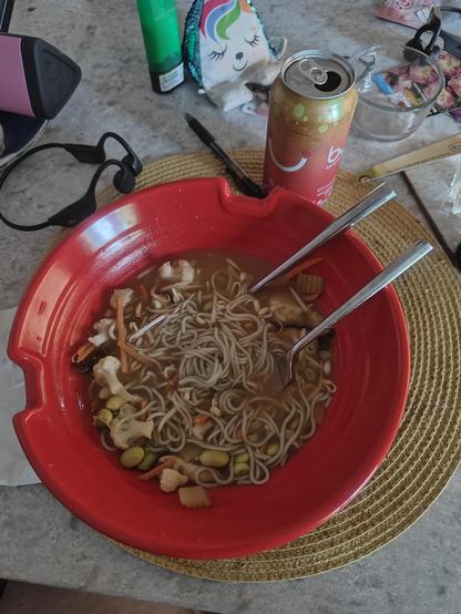 Ramen noodles, broth and veggies in a big red bowl