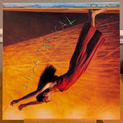 front cover with a woman in a dress standing upside down (floor is ceiling), back curved, arms outstretched