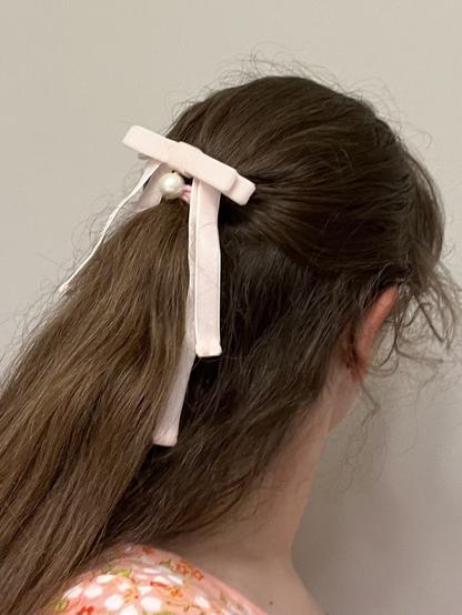 Hair with pink barrette with a pink velvet bow and pearl.
