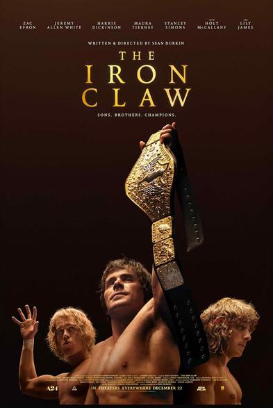 Movie poster for "The Iron Claw," featuring three male figures with one holding a championship wrestling belt. The background is dark, and the title is prominently displayed along with taglines "Sons. Brothers. Champions."