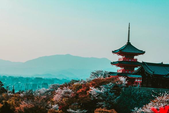 Une temple japonais s'affiche à droite au premier plan. Tout en bas la multitude de couleur des feuilles des arbres offrent un camaïeu. Dans le brume se dessine, une ville, un village. Puis au dernier plan, les alpes japonaises se confondent dans la brume et le ciel.