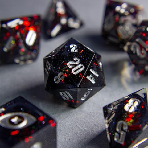 Zu sehen ist ein D20 mit schwarzen swirls. Die Swirls sind von roten Metallflakes und Glitter umgeben.

Die Nummern sind silber geinked.
