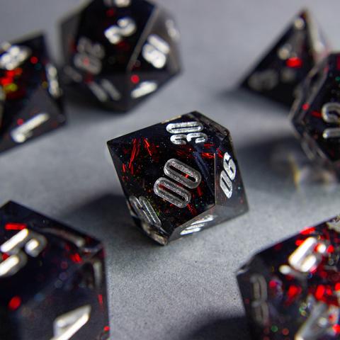 Zu sehen ist ein D100 mit schwarzen swirls. Die Swirls sind von roten Metallflakes und Glitter umgeben.

Die Nummern sind silber geinked.