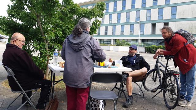 Hommes et femme se détendant au soleil avec boissons et en-cas, place de l'Europe.
