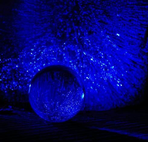 A block of ice that had shattered a vase was illuminated at night with blue light. A small glass sphere (approximately 3 cm in diameter) was placed in front of it, causing a point reflection of the ice block. The photo was cropped but not further edited: I'm a lazybones ; )