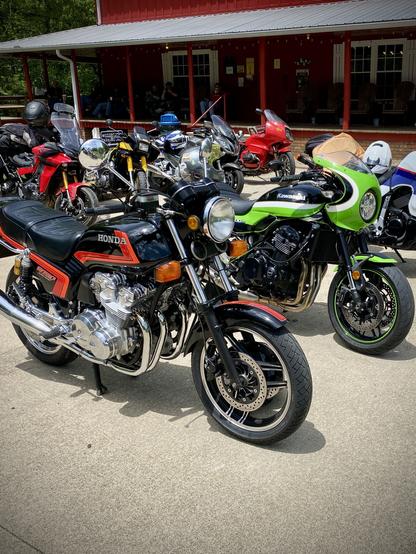 A vintage Honda CB750F motorcycle parked in front of bayport's Kawasaki and surrounded by other motorcycles all around.