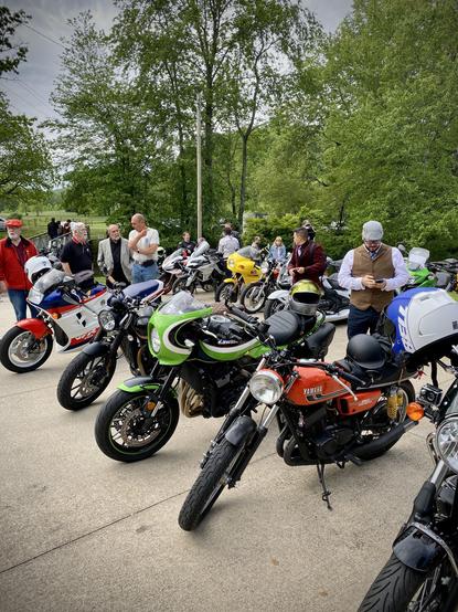 The row of parked motorcycles from the opposite angle. This angle shows a a vintage Yamaha TD350 motorcycle parked in front of bayport's bike.
