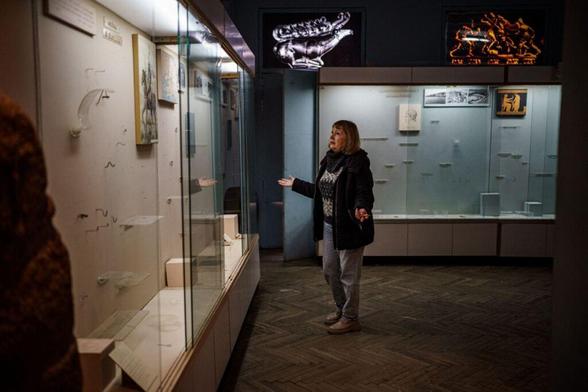 The interim director of the Kherson Regional Museum stands in front of empty display cases looted by Russian forces, in Kherson, Ukraine