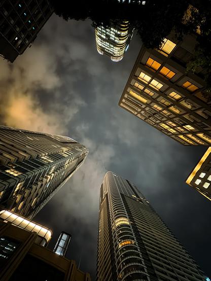 Photo of skyscrapers in the city of Tokyo, photographed straight from below so the towers pop up from every angle. The sky looks cloudy.