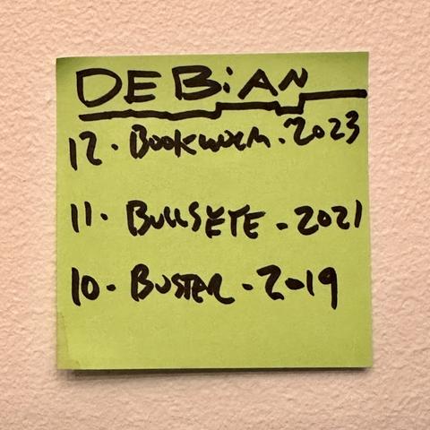 A sticky note with a “cheat sheet” to the last three Debian versions, including version numbers, code names, and release years. Every version code name starts with “B”.