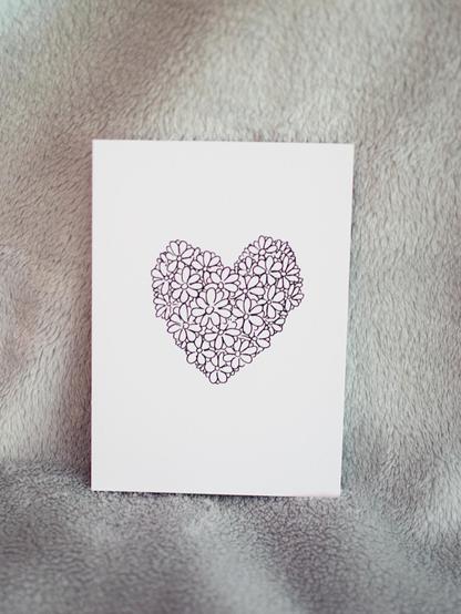 Eine Postkarte auf der ein Herzen bestehende aus Blüten zu sehen ist
s/w

A postcard on which a heart made of flowers can be seen
b/w