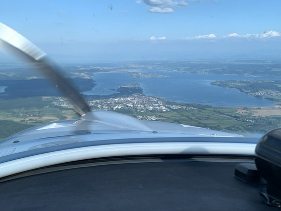Cockpit view, east bound: the centre shows the town of Radolfzell at the Lake of Constance. Below the horizon the island of Reichenau and Konstanz are visible. Above the horizon a thin layer of clouds.