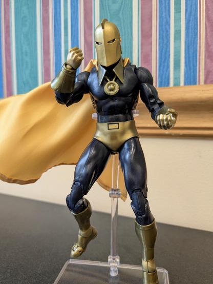 DC Multiverse Silver Age Doctor Fate (Platinum) on a stand floating with his cape billowing to his right. His right hand is in front of his face in a fist, and his left is cupped as if holding something (there is nothing in his hand)