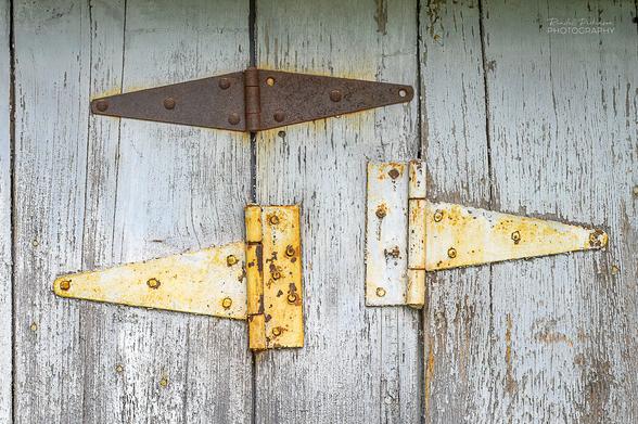 Three hinges attach two garage doors to a center post.