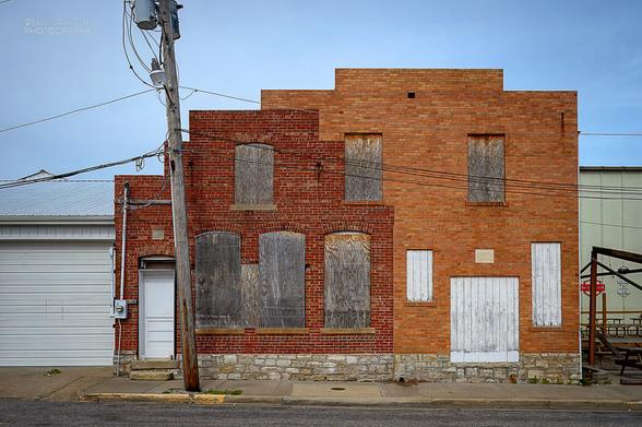 A building consisting of a center brick portion erected in 1923, a brick addition on the right added in 1940, and a modern metal building on the left.