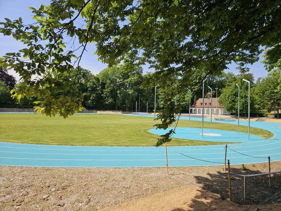 Foto einer Sportanlage mit türkisfarbener Tartanbahn