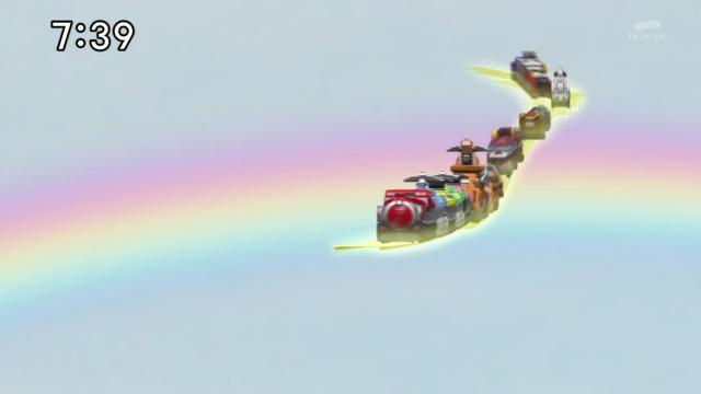 A screenshot from Ressha Sentai ToQger showing the trains of the Rainbow Line running across a rainbow in the background