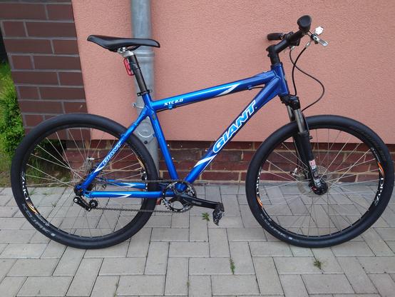 ein blaues single speed 26" MTB lehnt an einer hauswand.