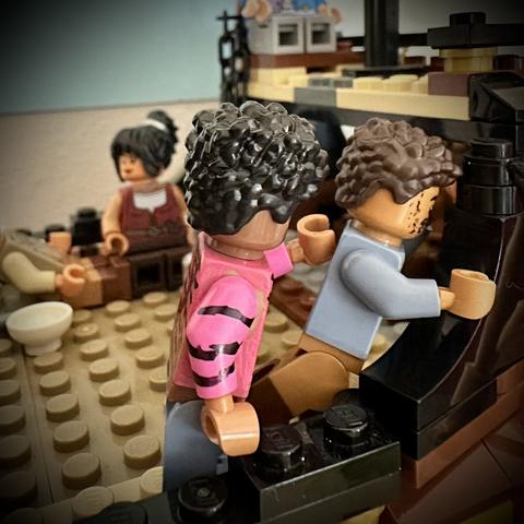 Lego Roach patting Lego Frenchie on the back, who is pressing his head against the edge of the ship in distress