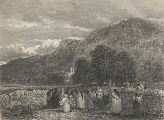 A procession of Welsh mourners on the way to a countryside churchyard flanked by a Welsh mountain ridge.