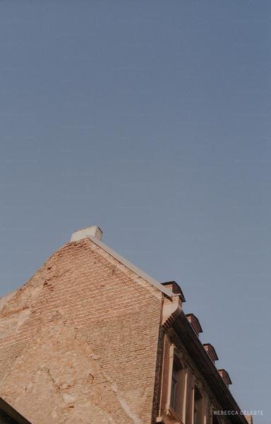 A house with a brick wall and a cloudless sky.